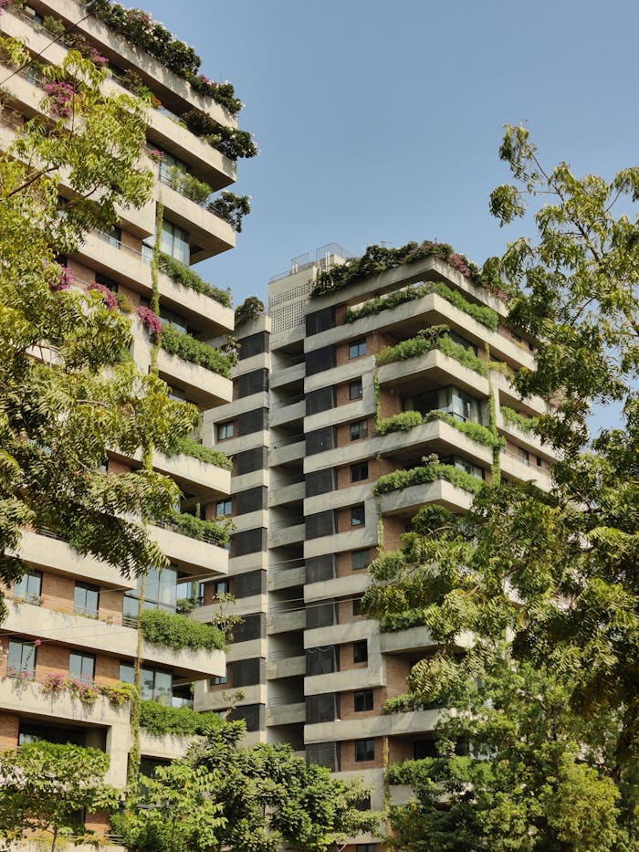 Modern residential buildings with lush green balconies in Ahmedabad, India.